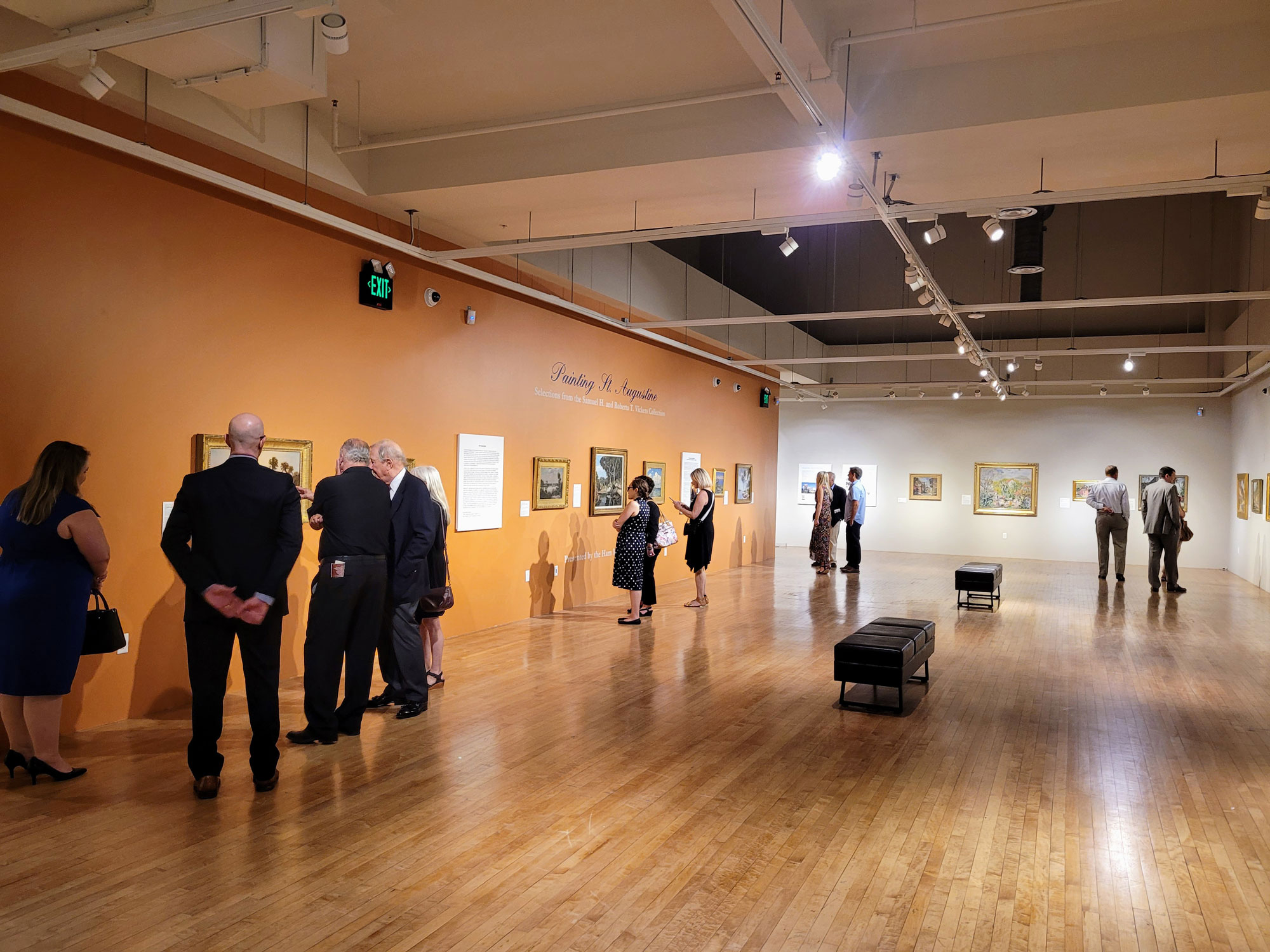 Gallery inside the Governors House with people walking around viewing historic artwork