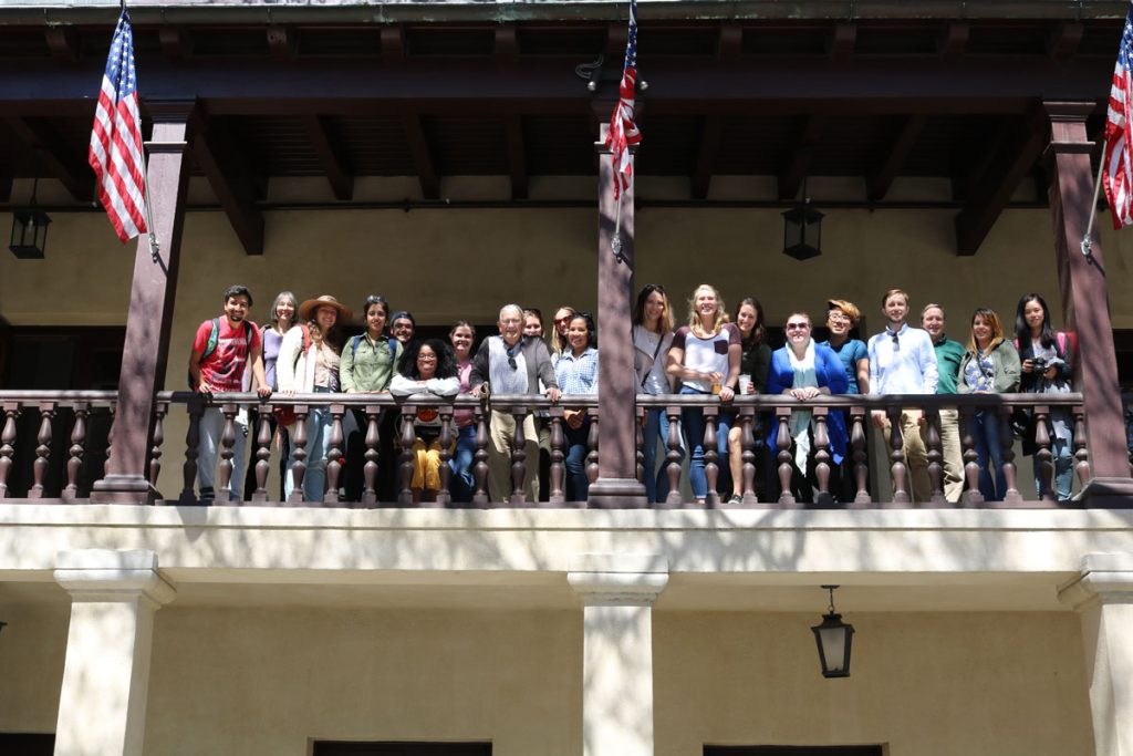 Students and professors on the balcony of the Governors house with american flags on the columns